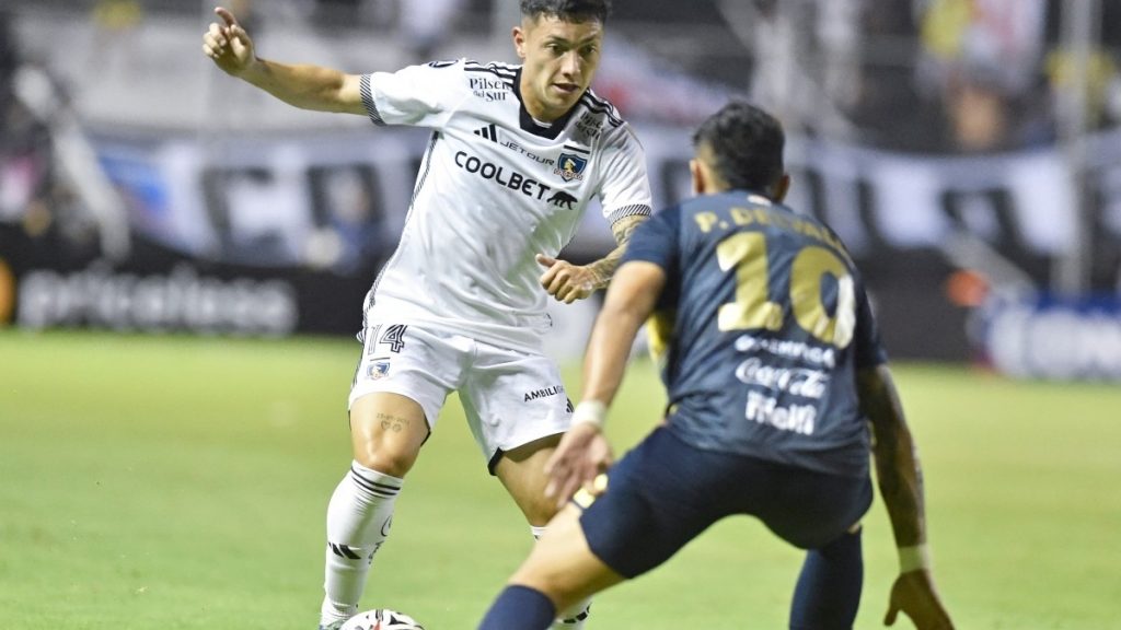 El delantero de Colo Colo Cristian Zavala encarando a un jugador paraguayo del Sportivo Trinidense.