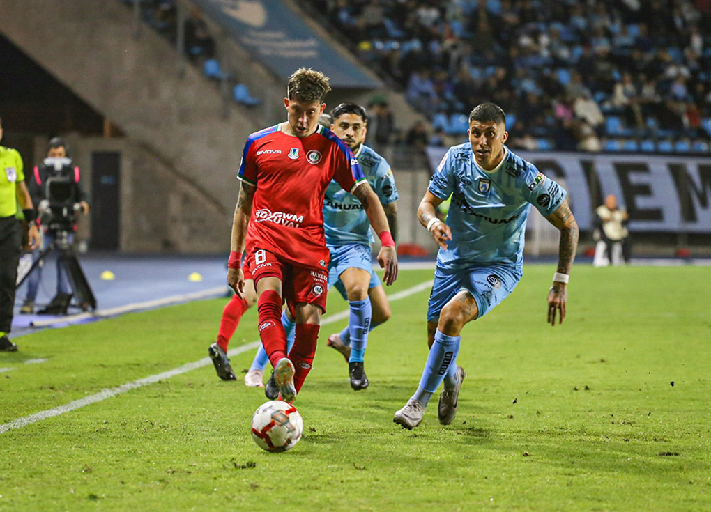 Jugadores de Deportes Iquique y Unión La Calera yendo a luchar el balón.