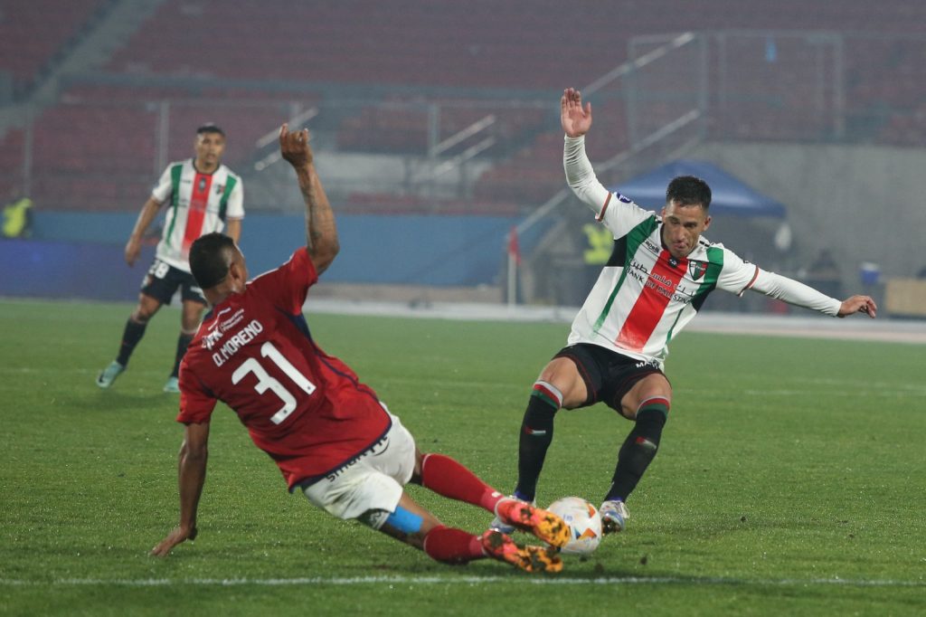 Jugadores de Palestino y Medellín yendo a disputar el balón.